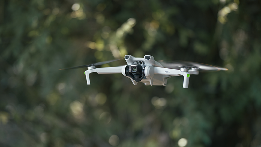Dron DJI Mini 3 podczas lotu w lesie