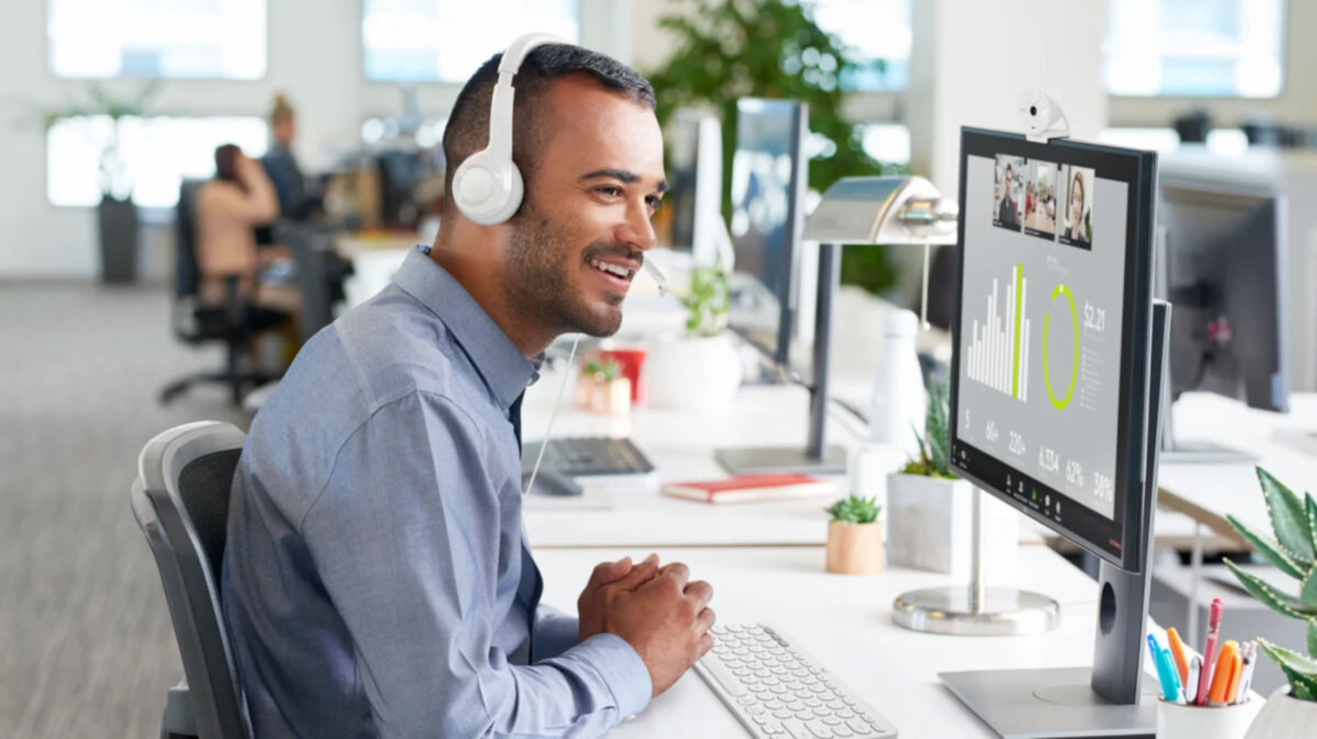 Słuchawki Logitech H390 białe grafika przedstawia mężczyznę siedzącego w biurze przed monitorem ze słuchawkami na uszach