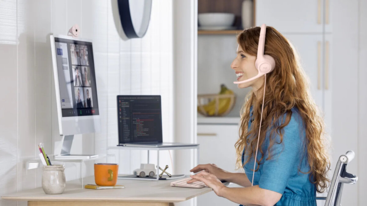 Słuchawki Logitech H390 białe grafika przedstawia kobietę siedzącą przed monitorem która prowadzi wideorozmowę ze słuchawkami na uszach