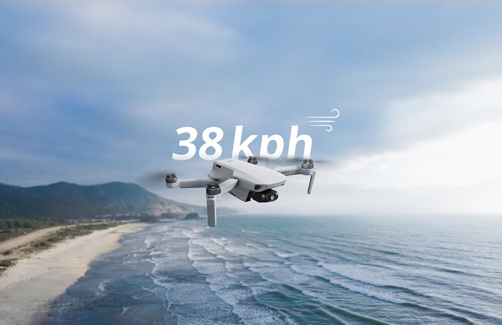 Dron DJI Mini 2 SE Single CP.MA.00000573.01 widok na drona lecącego nad plażą ze wskazaną na grafice odpornością na wiatr wynoszącą 38 km/h